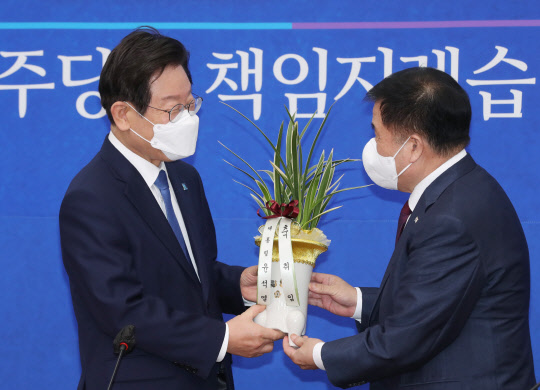 이재명 민주당 신임 대표가 30일 국회 대표실을 방문한 이진복 대통령실 정무수석으로부터 축하난을 받고 있다. 국회사진기자단=연합뉴스